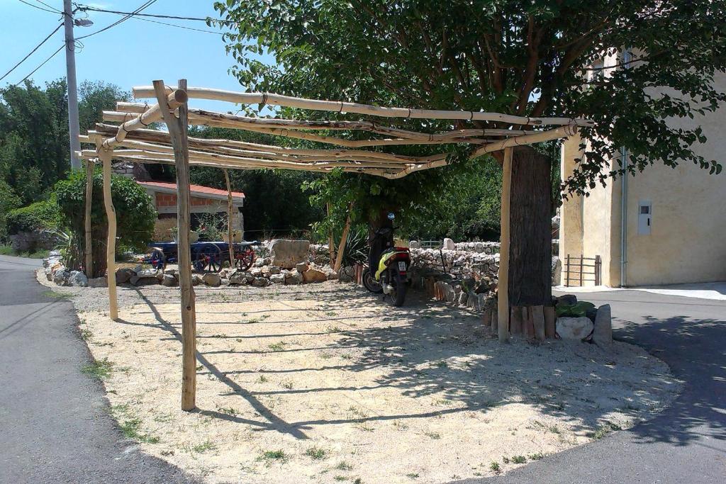 a wooden pergola on the side of a road at Apartments with a parking space Zupanje, Krk - 5307 in Županje