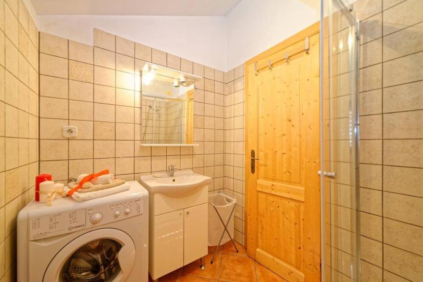 a bathroom with a washing machine and a sink at Apartments with a parking space Zupanje, Krk - 5307 in Županje