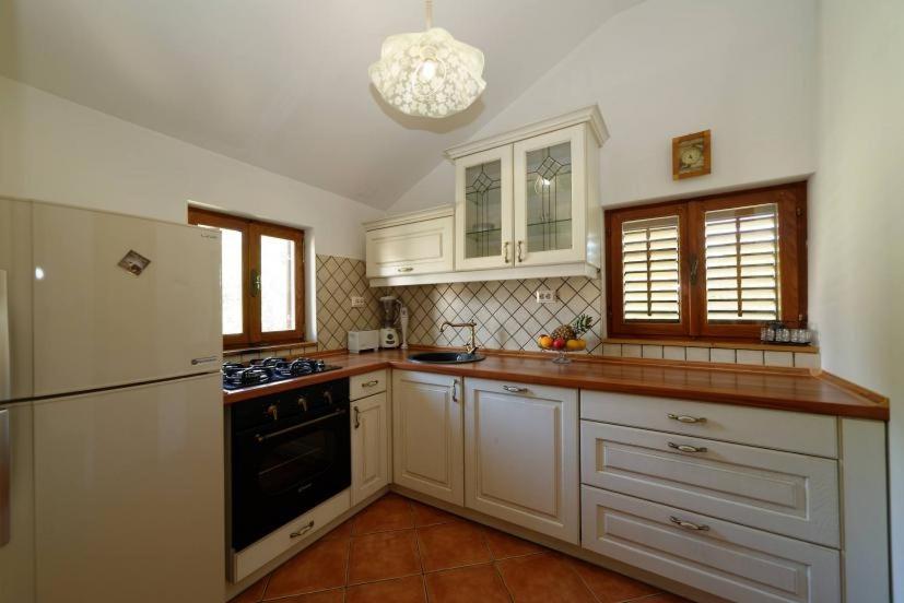 a kitchen with white cabinets and a white refrigerator at Apartments with a parking space Zupanje, Krk - 5307 in Županje