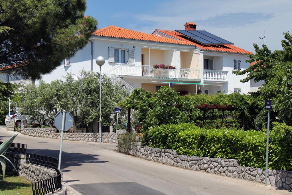 a white house with solar panels on the roof at Apartments with a parking space Krk - 5371 in Krk
