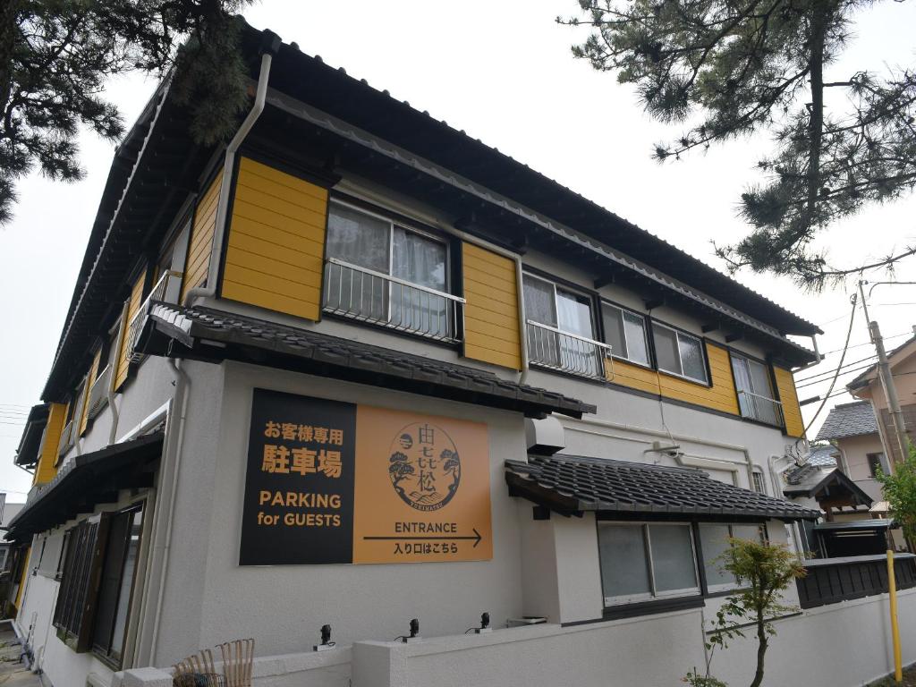 a yellow and white building with a sign on it at 由㐂松 in Nishiizu