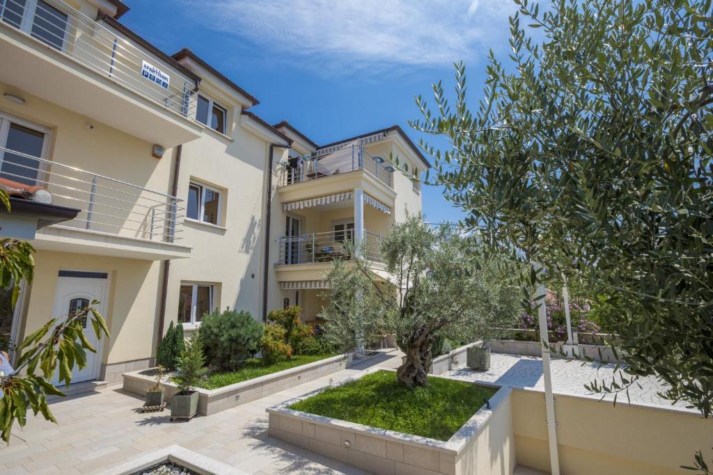 an apartment in a building with a tree in a courtyard at Apartments by the sea Selce, Crikvenica - 5367 in Selce