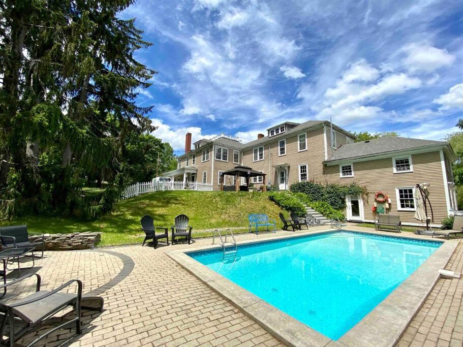 a swimming pool in front of a house at The Jarvis Homestead - Historic Maine Mansion in Ellsworth