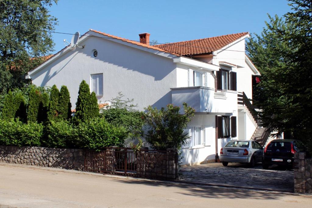 una casa bianca con una macchina parcheggiata di fronte di Apartments with a parking space Vantacici, Krk - 5425 a Vantačići