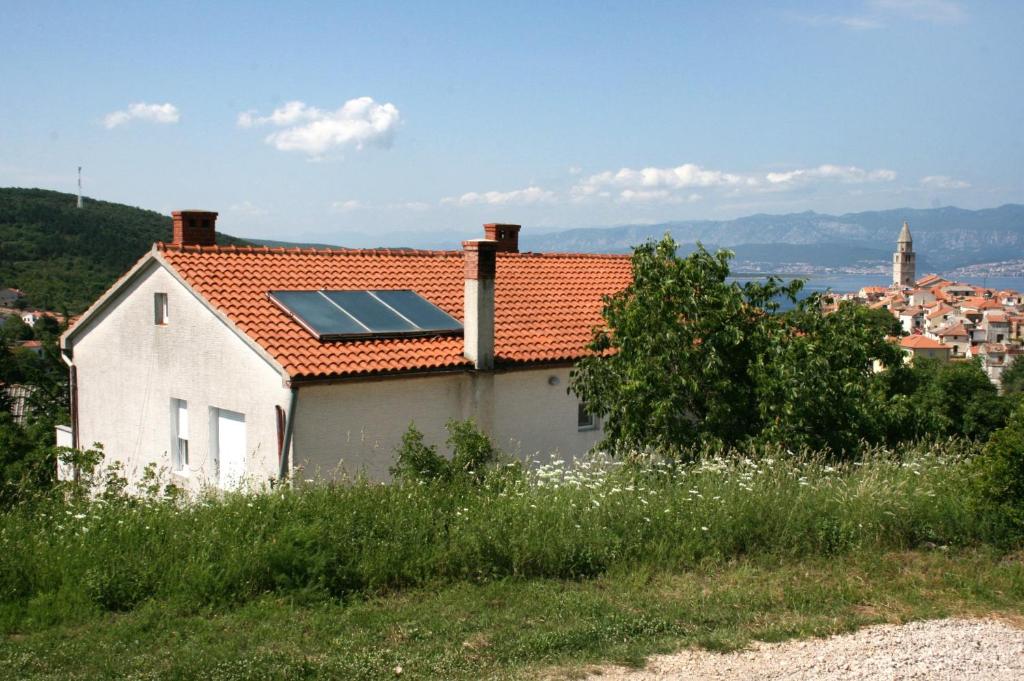 a house with a solar roof with a city in the background at Apartments with a parking space Vrbnik, Krk - 5392 in Vrbnik