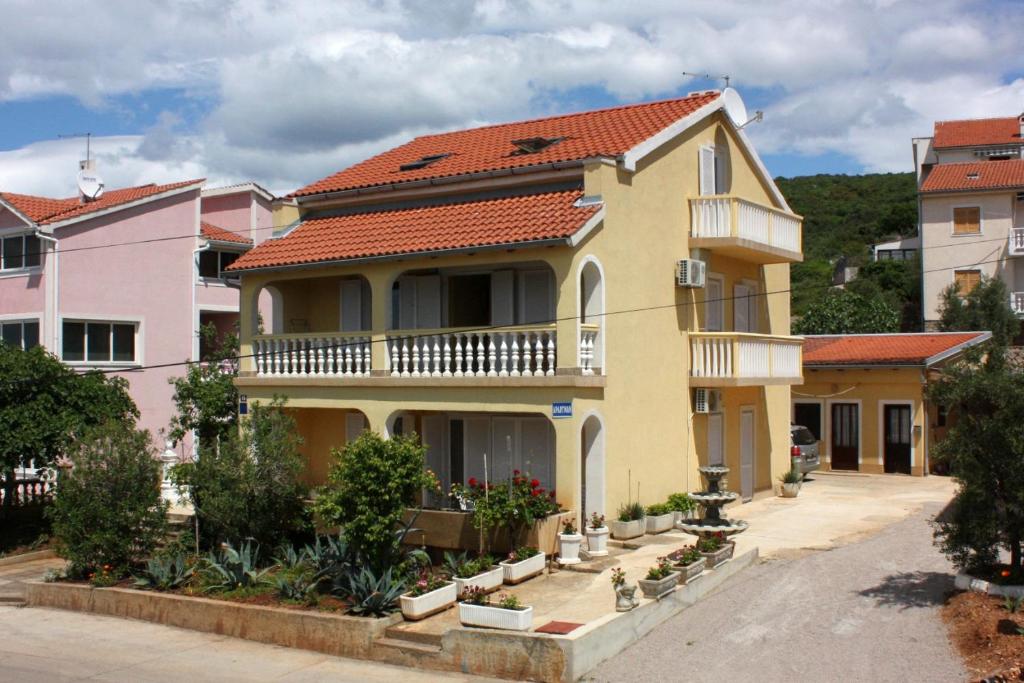 a large yellow house with a red roof at Apartments with a parking space Punat, Krk - 5350 in Punat