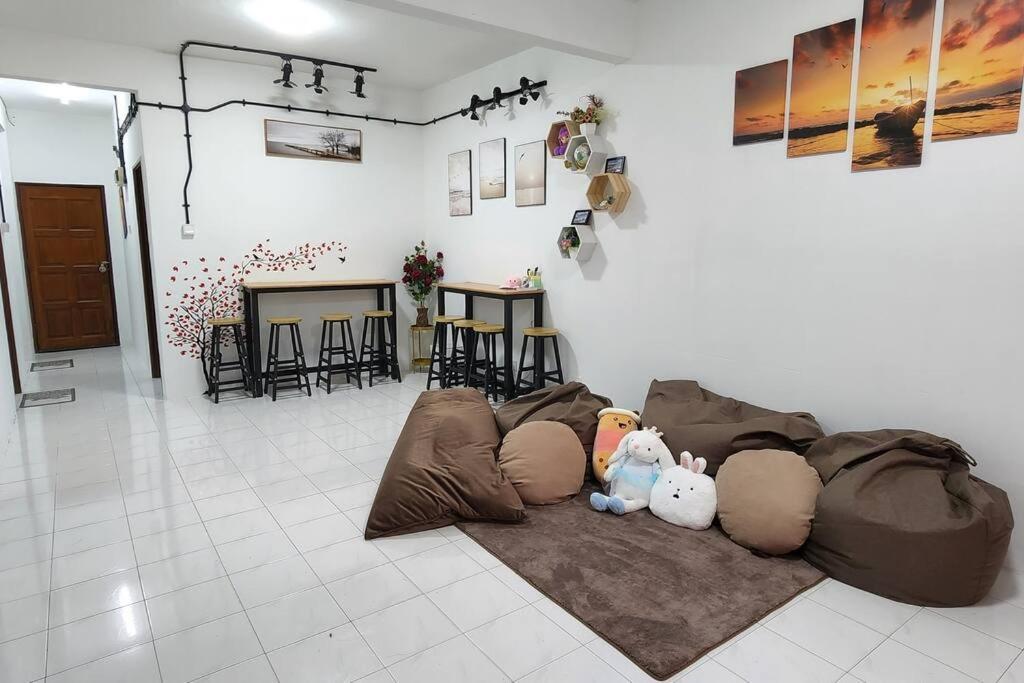 ein Wohnzimmer mit einer Couch mit ausgestopften Tieren darauf in der Unterkunft The Homestay 105 - nearby sky mirror jetty - Netflix & xbox in Kuala Selangor