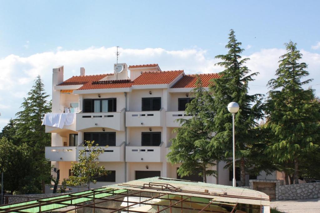 un bâtiment avec un court de tennis en face dans l'établissement Apartments with a parking space Punat, Krk - 5375, à Punat