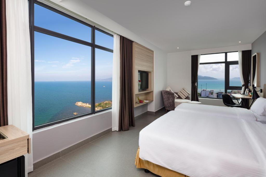 a bedroom with a large bed and a large window at Anrizon Hotel Nha Trang in Nha Trang