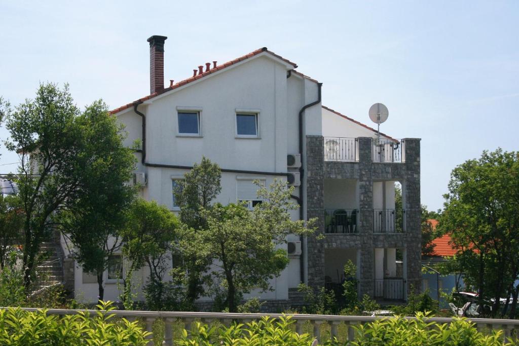Biały budynek z balkonem na boku w obiekcie Apartment Pinezici 5464c w mieście Pinezići