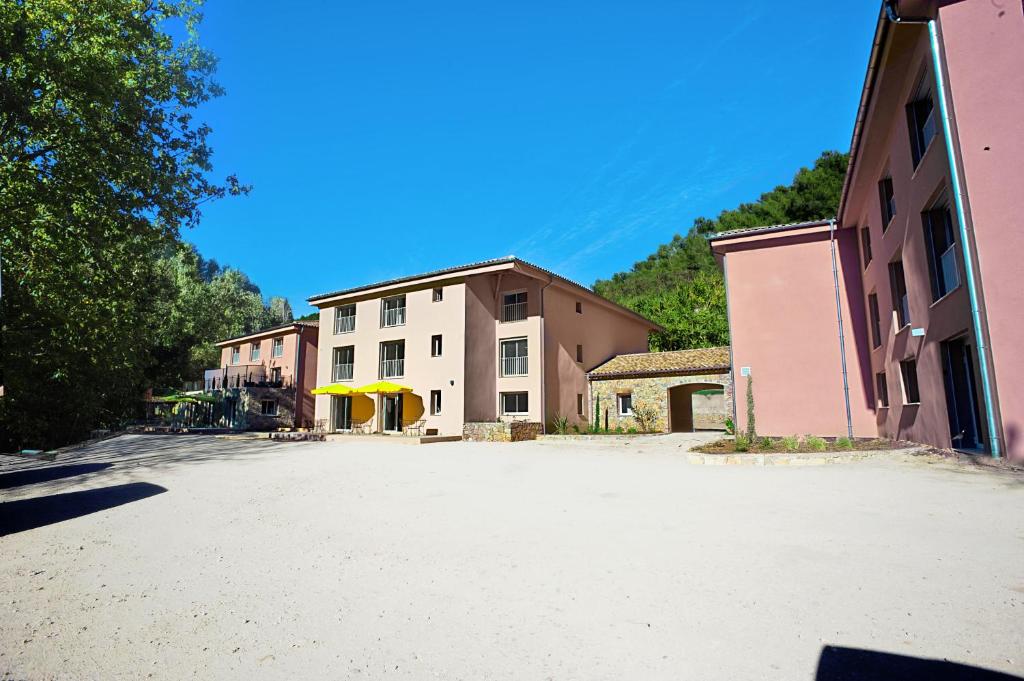 un gran aparcamiento en un pueblo con un edificio en The Originals City, Hôtel Les Bastides du Gapeau, en Solliès-Toucas