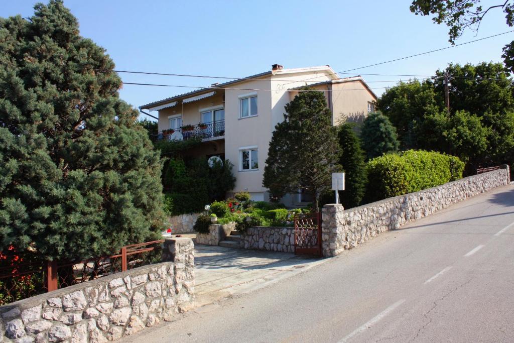 a house on the side of a road with a stone wall at Apartments with a parking space Smrika, Kraljevica - 5338 in Šmrika
