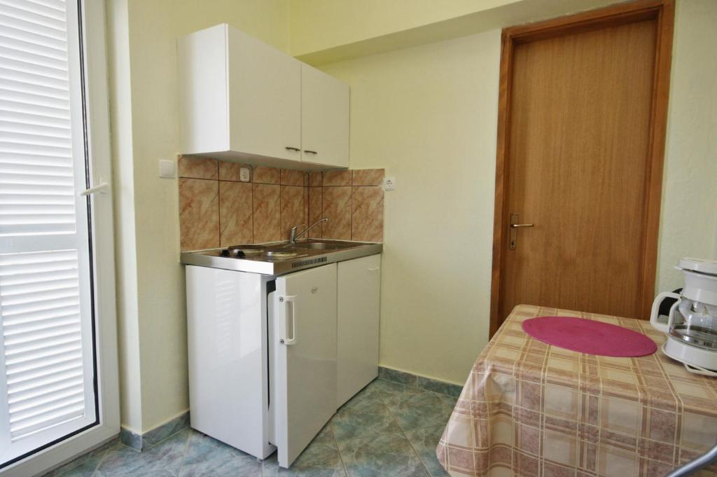 een kleine keuken met een wastafel en een koelkast bij Apartments with a parking space Novi Vinodolski - 5526 in Novi Vinodolski