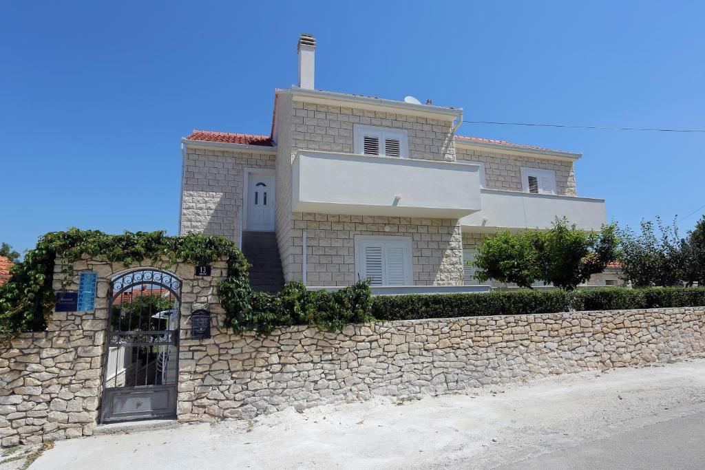 a stone wall in front of a house at Apartments with a parking space Supetar, Brac - 5385 in Supetar
