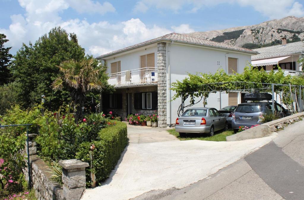 a house with two cars parked in the driveway at Apartments with a parking space Baska, Krk - 5407 in Baška
