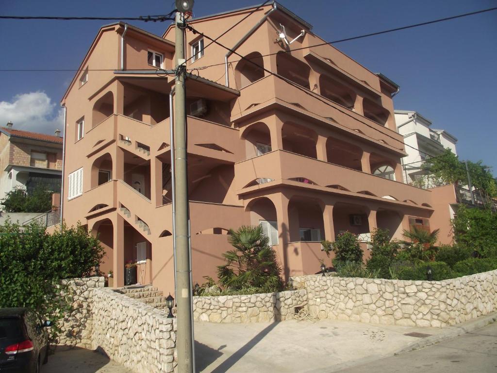 un edificio alto con una pared de piedra delante en Apartments with a swimming pool Novi Vinodolski - 5479, en Novi Vinodolski