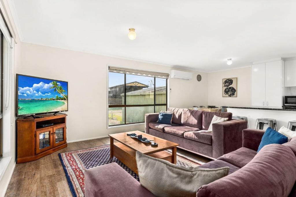 a living room with two couches and a tv at Panoscape in Sunset Strip