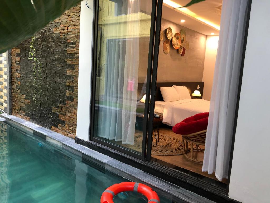 een slaapkamer met een bed en een zwembad bij PHỐ CHỢ ĐÊM Villa in Hội An