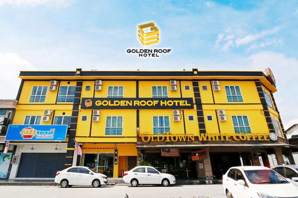 a yellow building with cars parked in front of it at Golden Roof Hotel Falim Ipoh in Ipoh