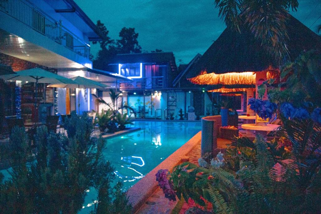a swimming pool at a resort at night at Blue Moon Inn in Dauis