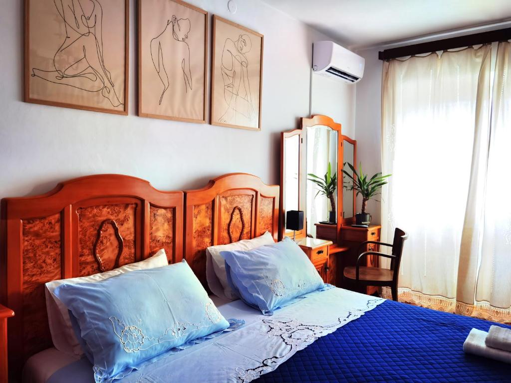 a bedroom with a bed with two blue pillows at Charming House Ruža in Korčula Town in Korčula