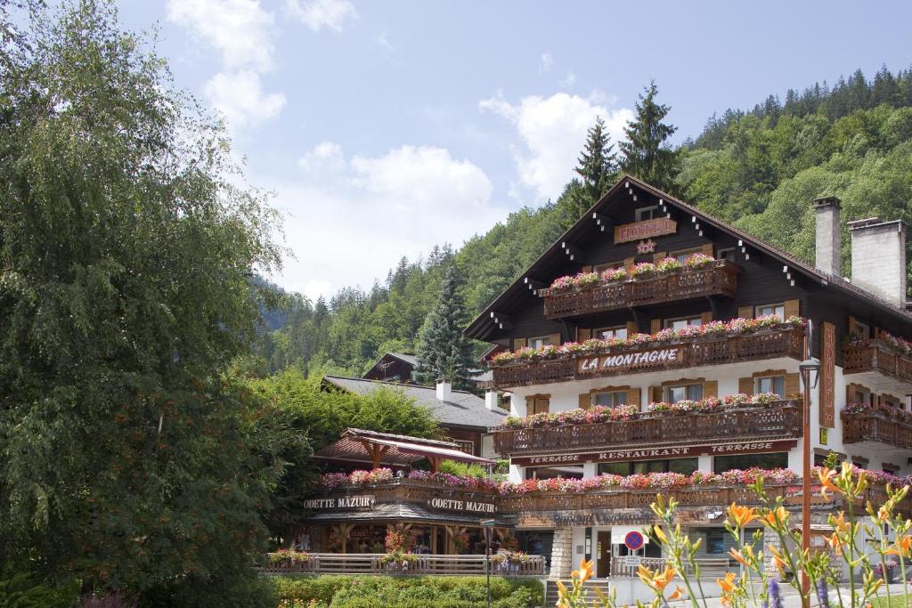 ein Gebäude mit Blumenkästen an der Seite in der Unterkunft Hotel La Montagne in La Clusaz