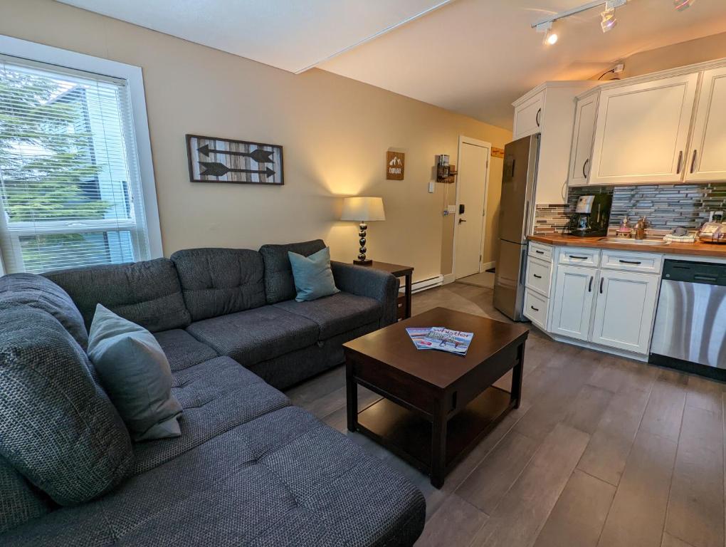 a living room with a couch and a table at Steps to All New Gondola, Sleeps 4 with Free Parking in Whistler