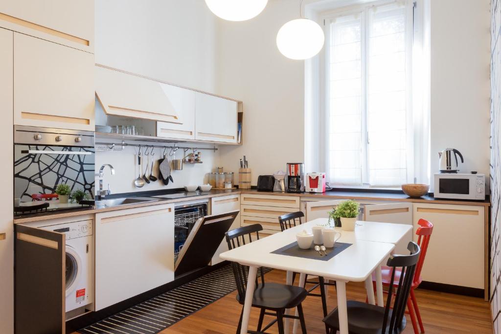 eine Küche mit einem Tisch und Stühlen in der Unterkunft The Best Rent - Apartment near Porta Romana in Mailand