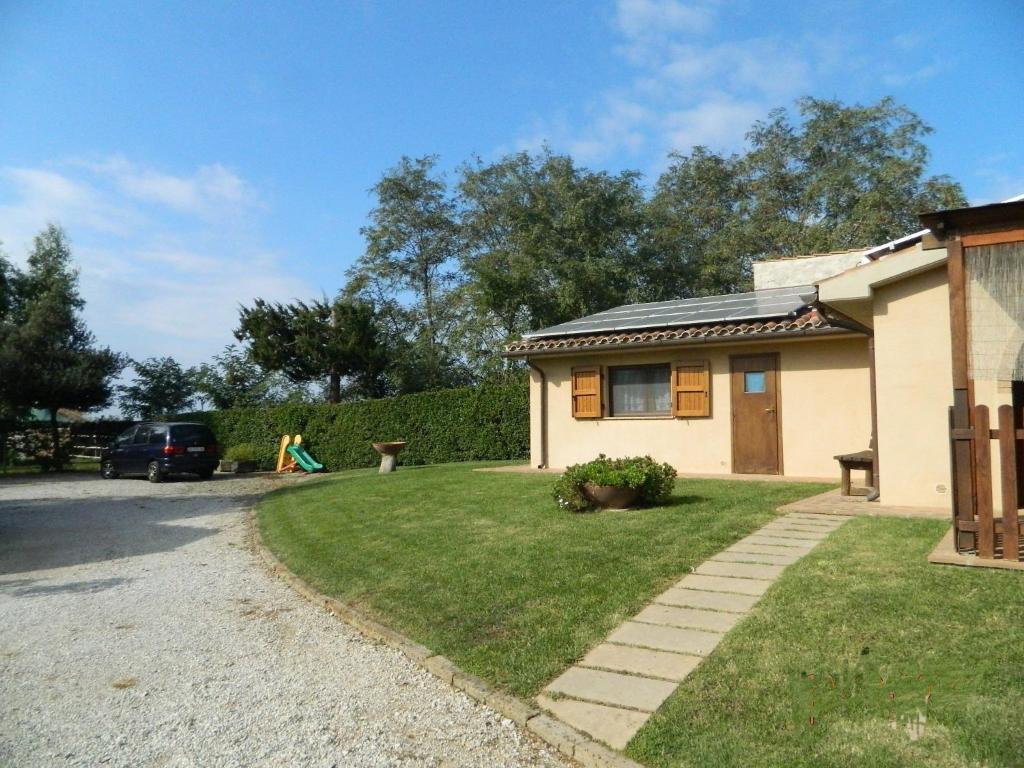 a house with a grassy yard next to a driveway at Podere Santo Signoretto in San Vincenzo