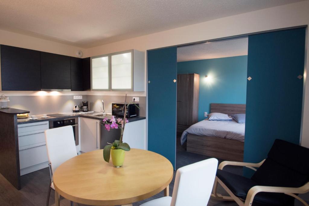 a kitchen with a table and a room with a bed at Le Manoir Domaine de la Motte in Saint-Dyé-sur-Loire