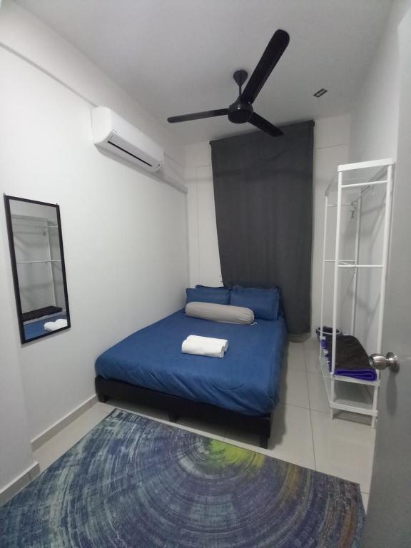 Schlafzimmer mit einem blauen Bett und einem Deckenventilator in der Unterkunft SAFIYYA HOMES MERU RAYA - WIFI/NETFLIX in Ipoh