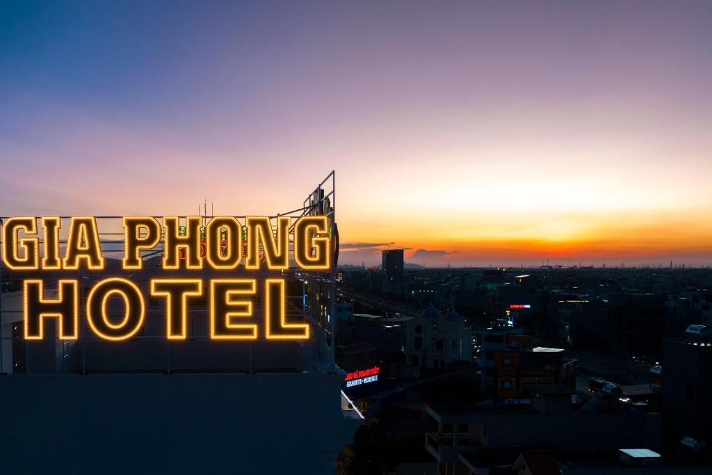 a sign on top of a building with the sunset in the background at Gia Phong Hotel in Xóm Niêm