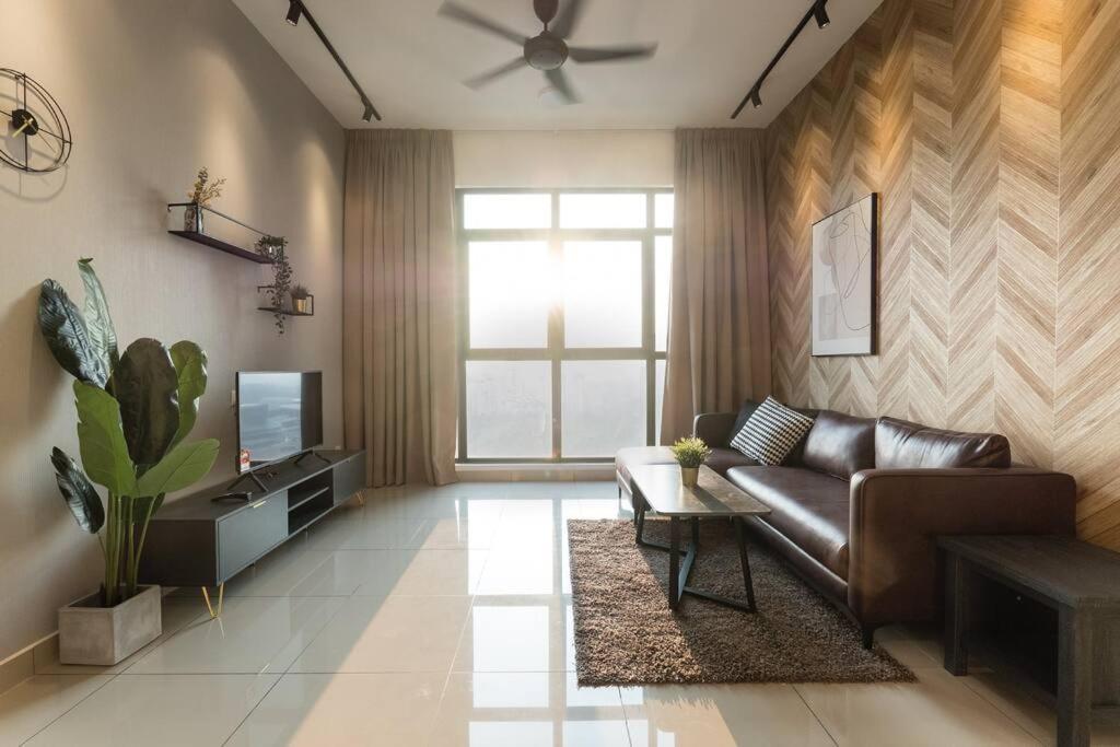 a living room with a leather couch and a television at Conezion Residence Putrajaya 3BR6Pax IOI City Mall in Putrajaya