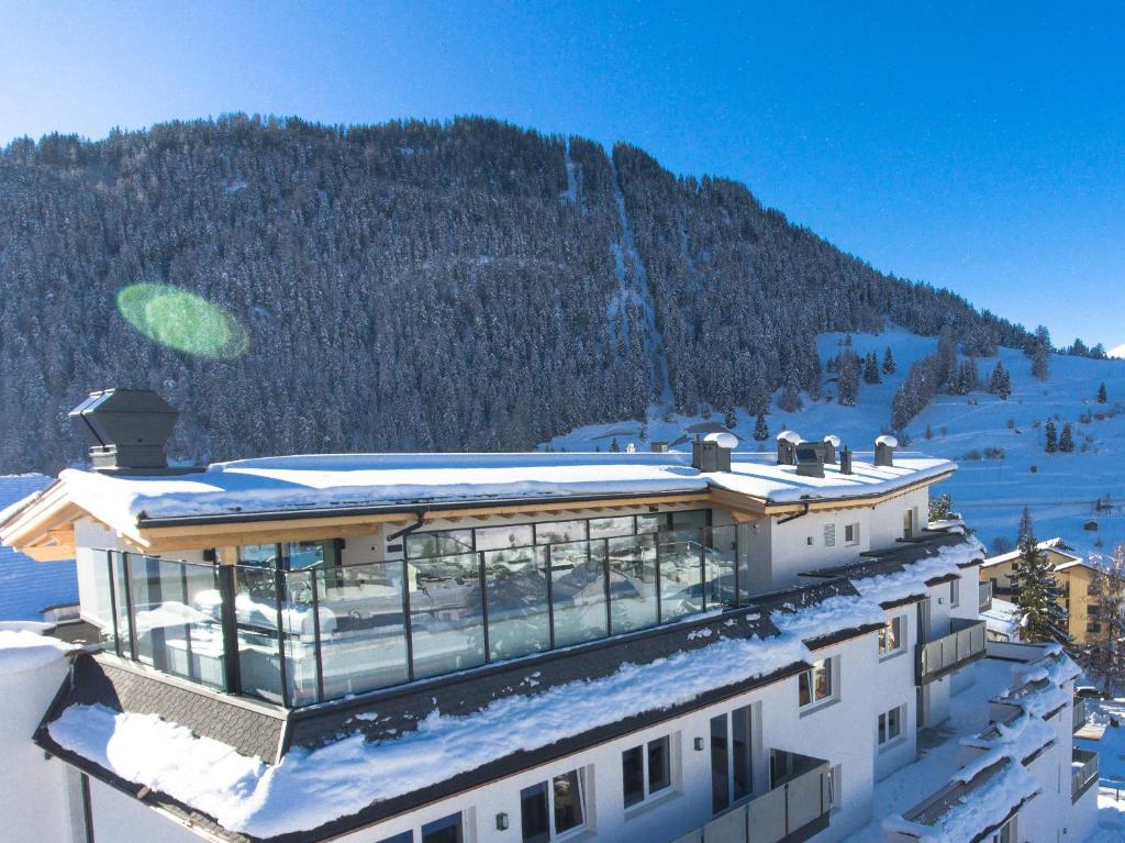 a building in the snow with a mountain in the background at Suites Nauders by mein Almhof Superior in Nauders