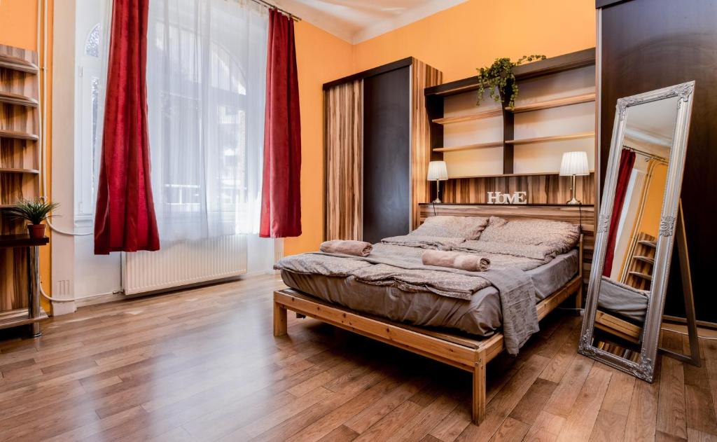 een slaapkamer met een groot bed en een spiegel bij Aurora Apartments in Boedapest