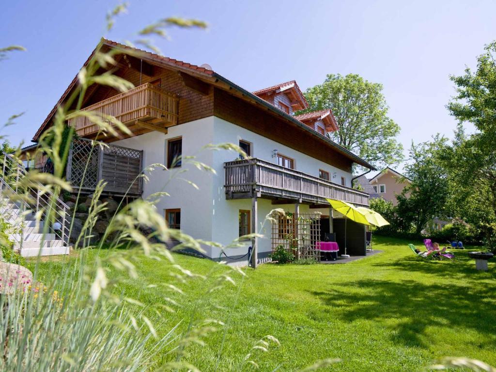 a large house with a grassy yard in front of it at Ferienwohnungen Haus Rachel in Neuschönau