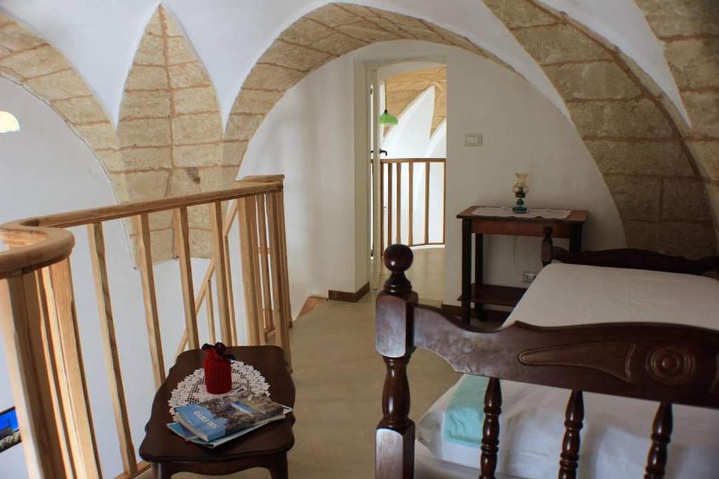a room with a staircase with a bed and a table at Casa Fadea in Gagliano del Capo
