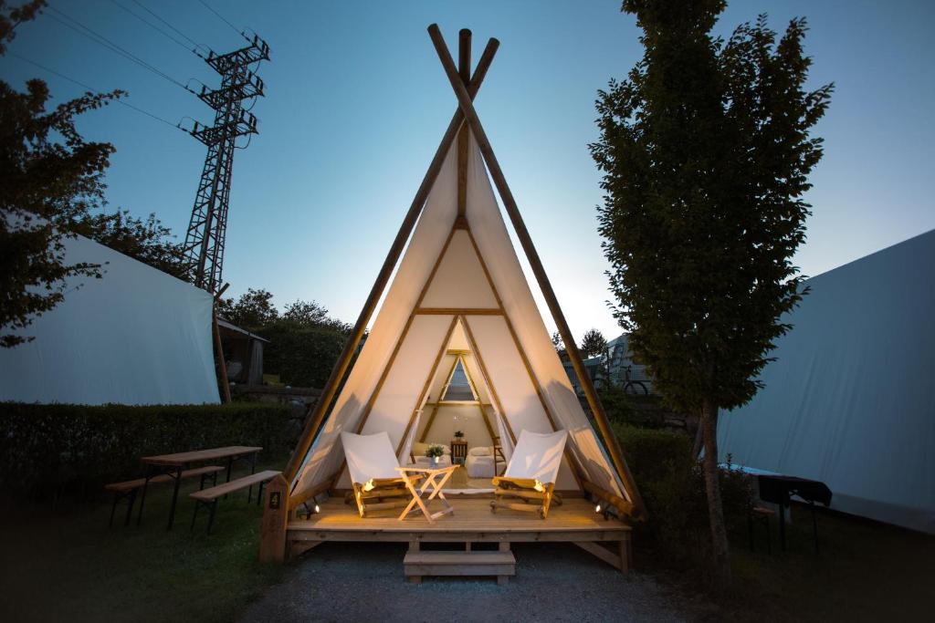 a small triangular tent with chairs and a table at Kampaoh Zumaia in Zumaia