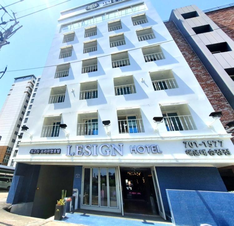 a white building with a sign for a hotel at SongJeong Lesign Hotel in Busan