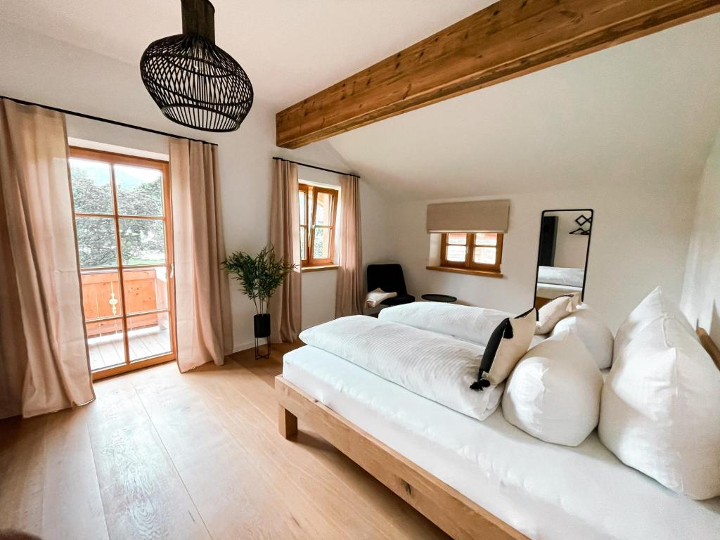 een slaapkamer met een groot wit bed met witte kussens bij Natur pur - Doppelhaushälfte im idyllischen Kreuth in Kreuth