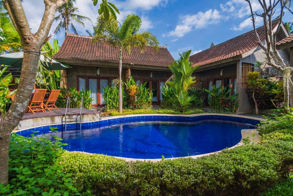 una piscina di fronte a una casa con un resort di Elemento Homestay Badung a Bringkit