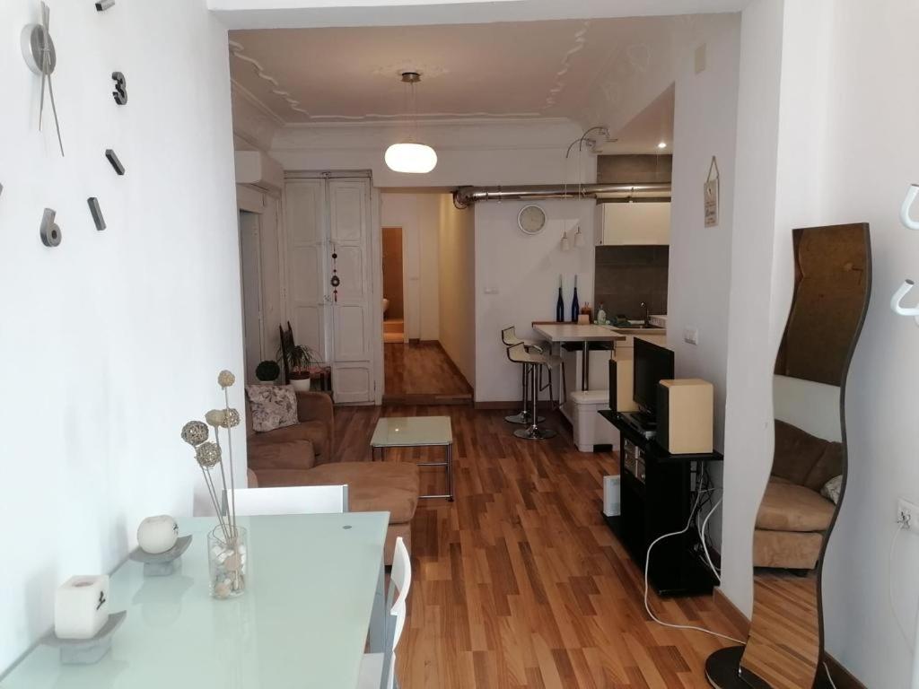 Apartamento con encanto Mila VALENCIAYOLE في فالنسيا: غرفة معيشة مع طاولة ومطبخ