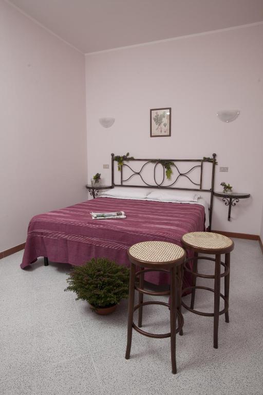 a bedroom with a bed with two chairs and a table at Bed & Breakfast Conca Verde in Cavriana