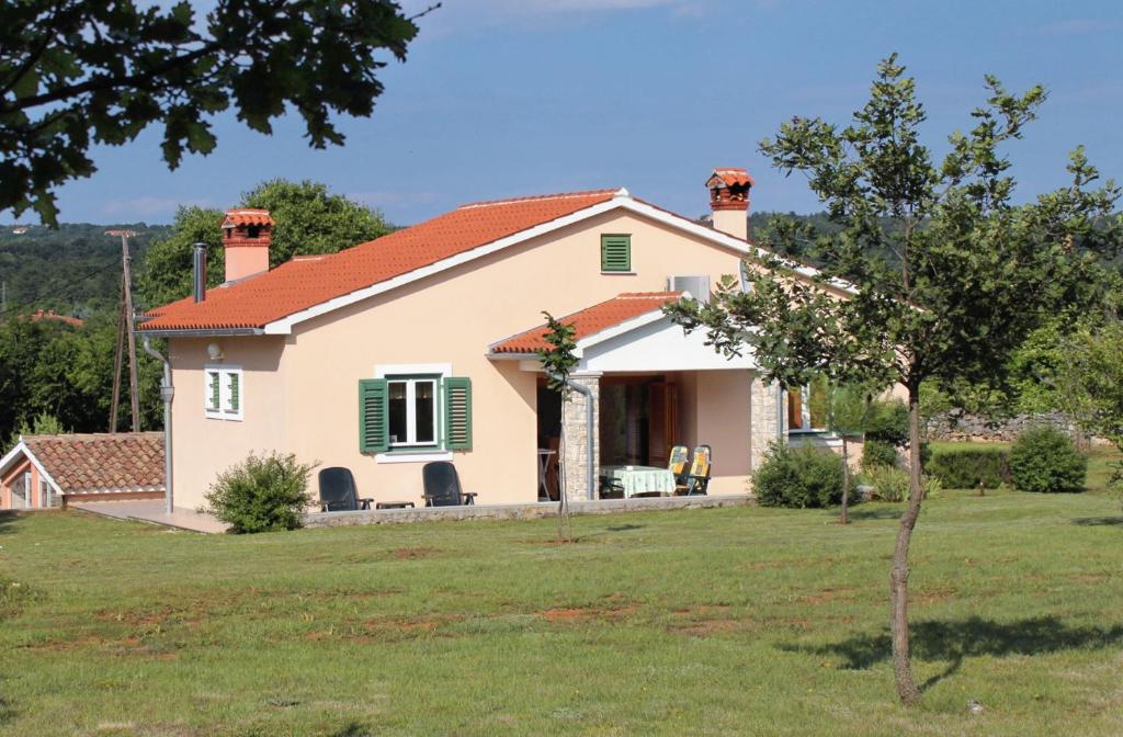a small white house with green shutters at Secluded family friendly house Kapelica, Labin - 5536 in Raša
