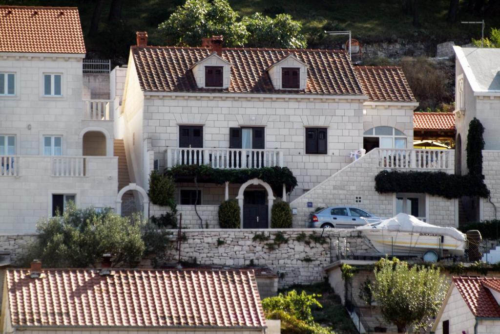 a house with a car parked in front of it at Apartments by the sea Pucisca, Brac - 5625 in Pučišća