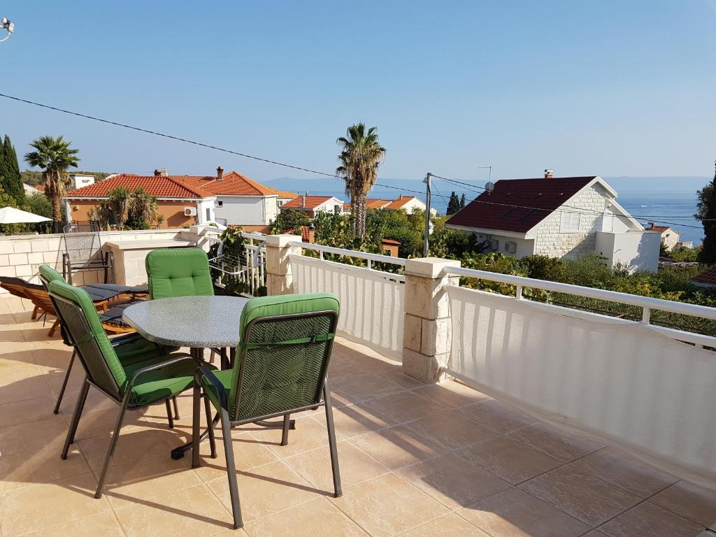 a patio with a table and chairs on a balcony at Apartments by the sea Sumartin, Brac - 5619 in Sumartin
