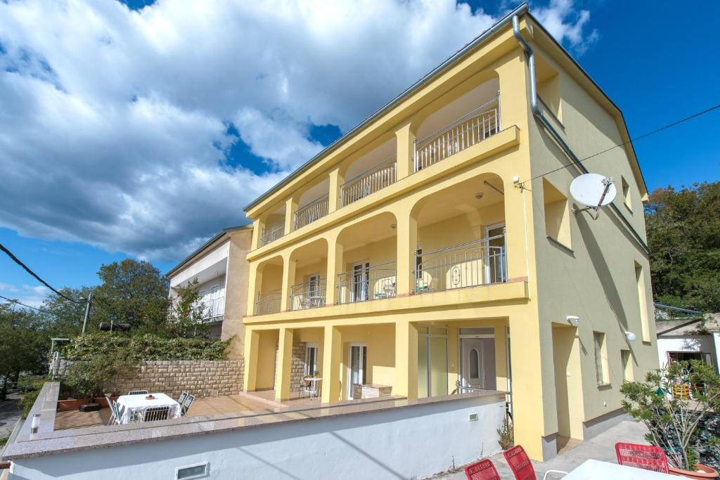 Una casa amarilla con balcón en la parte superior. en Apartments with a parking space Dramalj, Crikvenica - 5592, en Dramalj