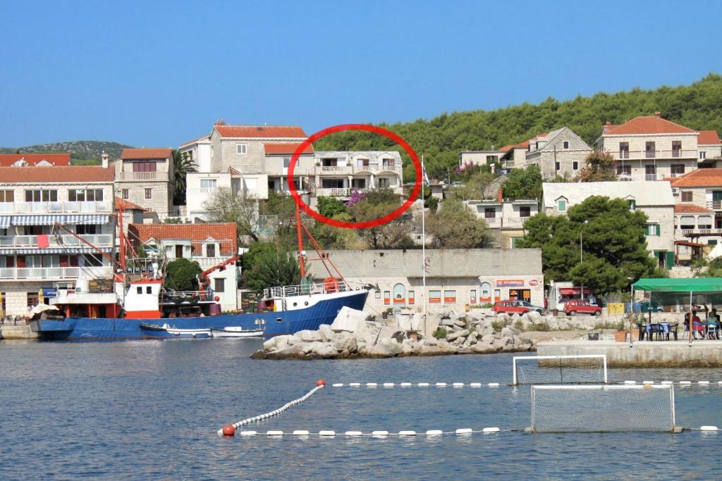 ein Boot im Wasser mit einem roten Kreis in der Unterkunft Apartments by the sea Sumartin, Brac - 5615 in Sumartin