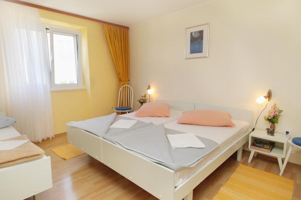 a bedroom with a white bed with orange pillows at Apartments by the sea Postira, Brac - 5660 in Postira