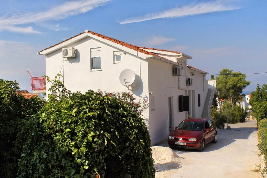 a red car parked in front of a white house at Apartment Sutivan 5629a in Sutivan